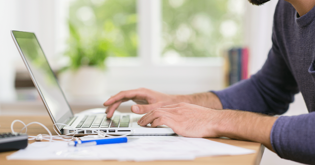 Close up of a person typing on a laptop