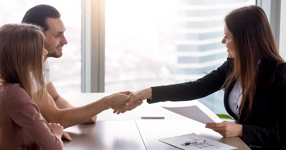 Business partners shaking the hand of a woman